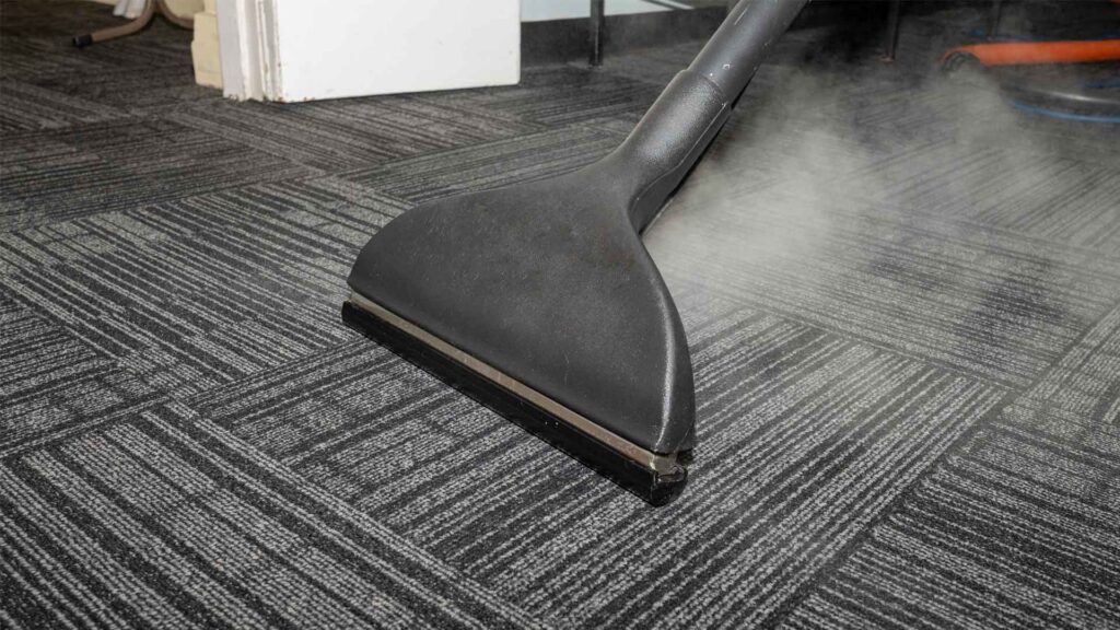 Carpet steam cleaning with a cleaning wand.