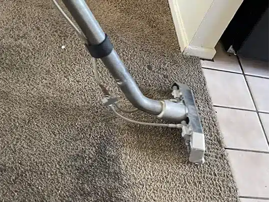 Cleaning a grey carpet that is very dirty.