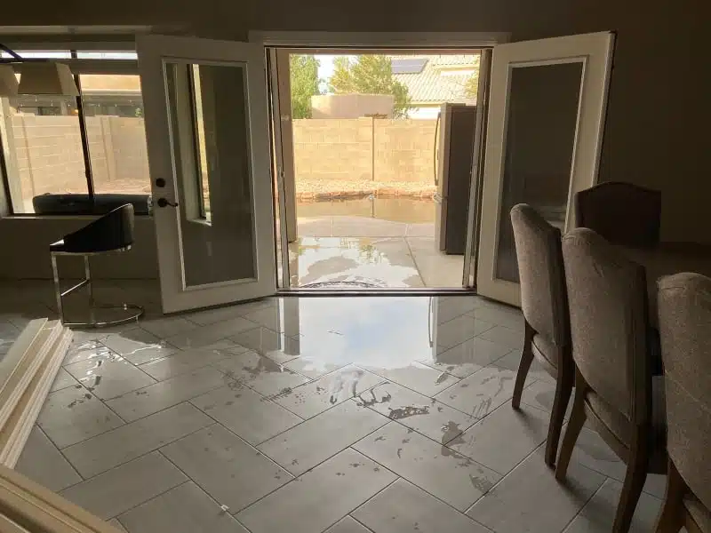 Flooded room with open doors to patio